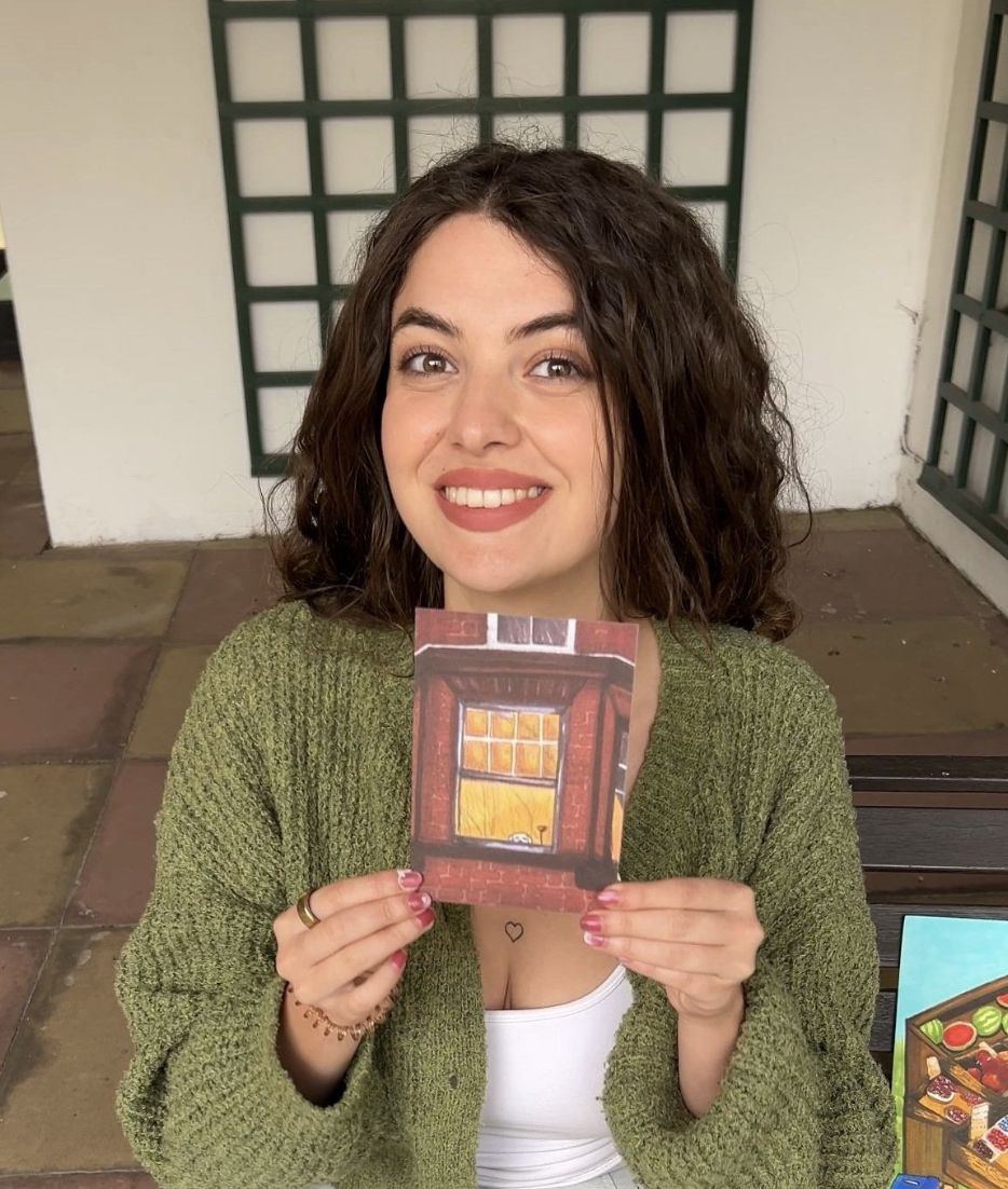 Emily holding one of her hand-drawn prints